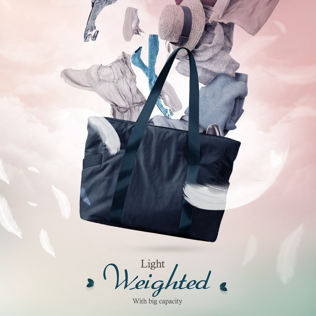 A creative composite image showing the navy blue tote bag floating among clouds and white feathers. Various clothing items, including jeans, a hat, and a dress, appear to be floating out of the bag, illustrating its storage potential. Text reads, "Light Weighted With big capacity."
