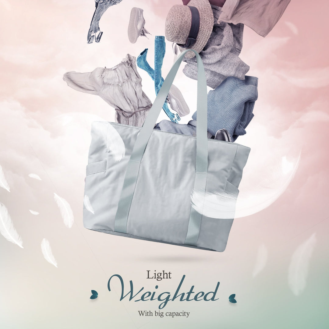 A creative composite image showing the gray tote bag floating among clouds and white feathers. Various clothing items, including jeans, a hat, and a dress, appear to be floating out of the bag, illustrating its storage potential. Text reads, "Light Weighted With big capacity."