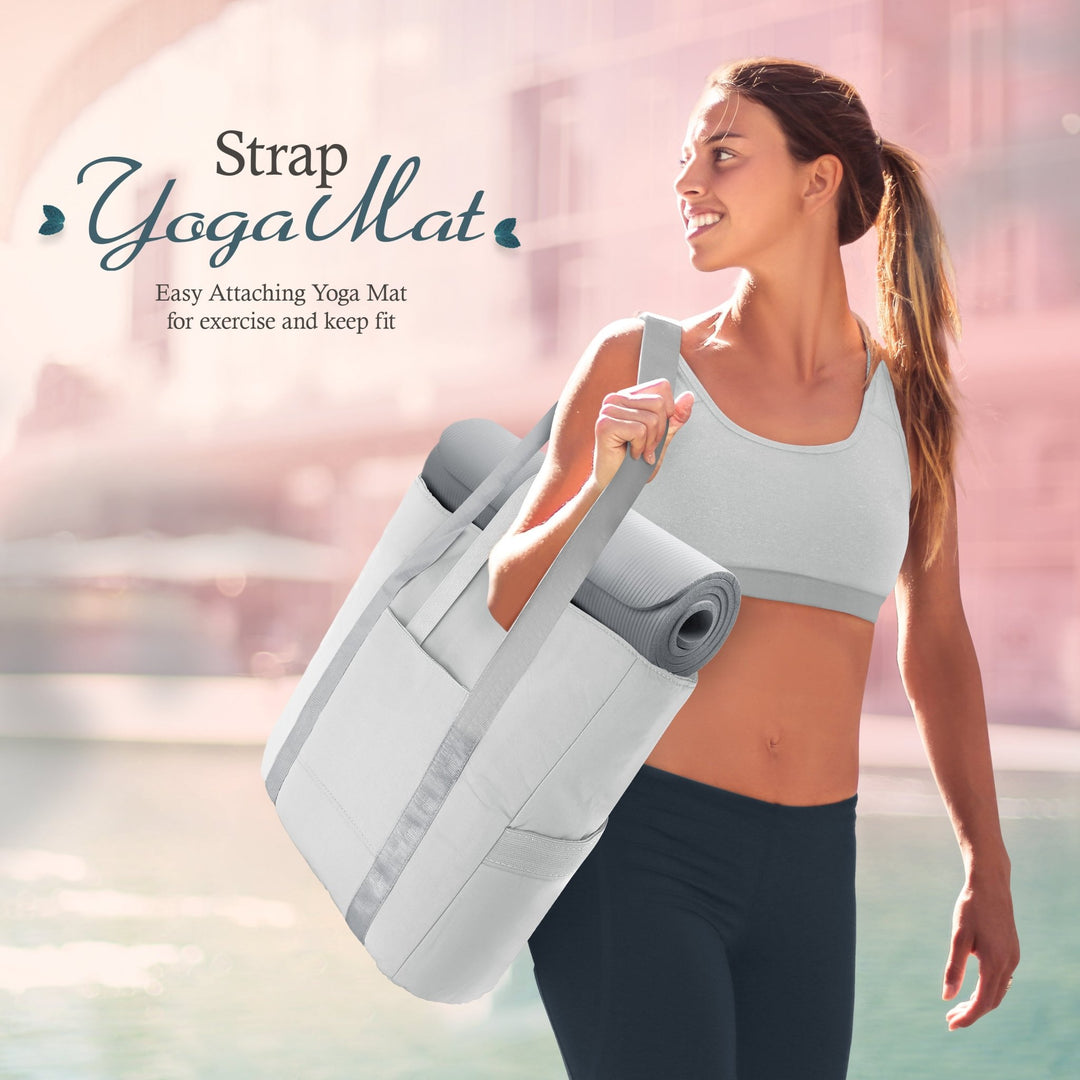 A lifestyle shot of a smiling woman in athletic wear carrying the gray tote bag on her shoulder. A rolled gray yoga mat is secured horizontally through the bag's straps. Text reads, "Strap Yoga Mat: Easy Attaching Yoga Mat for exercise and keep fit."